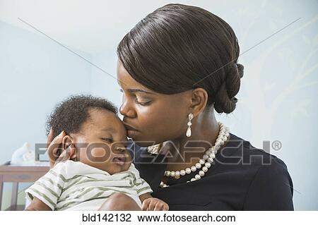 Stock Image - Mother kissing baby son. Fotosearch
