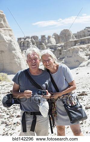 Stock Photograph - Older Caucasian couple exploring rock formations. Fotosearch