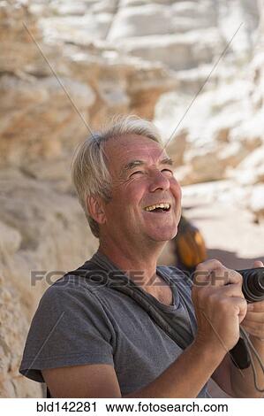 Older Caucasian man photographing rock formations View Large Photo Image Stock Image - Older Caucasian man photographing rock formations. Fotosearch