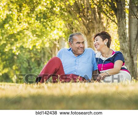 Older Hispanic couple sitting in grassy field View Large Photo Image Stock Photo - Older Hispanic couple sitting in grassy field. Fotosearch