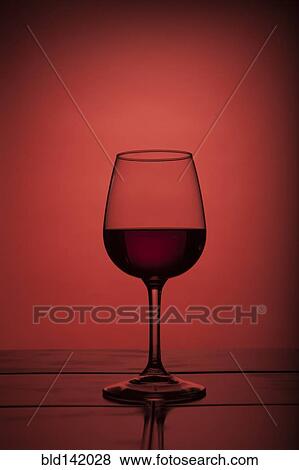 Red wine in wine glass on red background View Large Photo Image Stock Photo - Red wine in wine glass on red background. Fotosearch