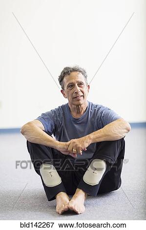 Stock Photo - Senior Caucasian man sitting on floor. Fotosearch