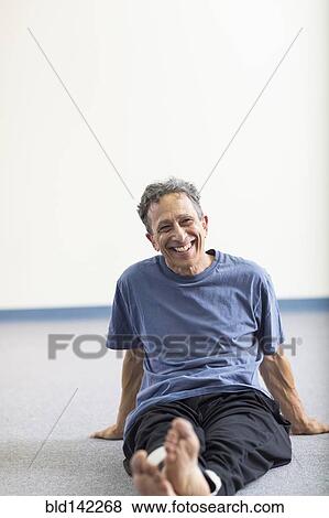 Stock Photo - Senior Caucasian man smiling on floor. Fotosearch