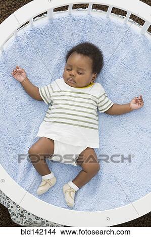 Picture - Sleeping baby laying in crib. Fotosearch
