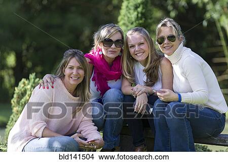 Picture - Smiling friends posing outdoors. Fotosearch