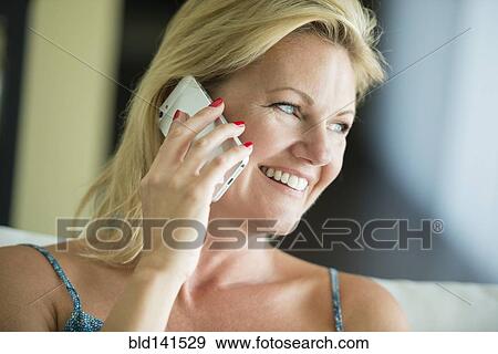 Stock Photo - Smiling woman talking on cell phone. Fotosearch