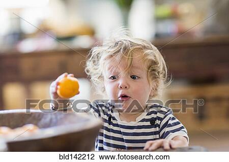 Surprised Caucasian baby boy examining fruit View Large Photo Image Stock Image - Surprised Caucasian baby boy examining fruit. Fotosearch