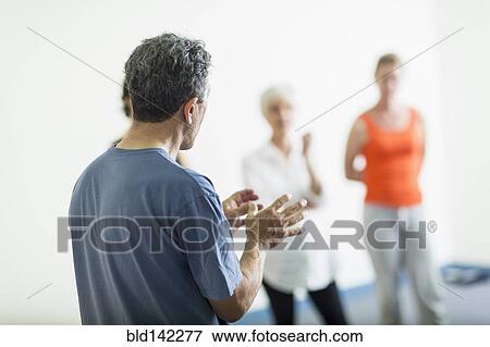 Stock Photo - Teacher talking to students in acting class. Fotosearch