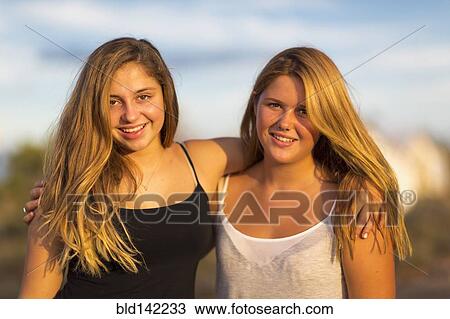 Teenage girls hugging outdoors View Large Photo Image Stock Image - Teenage girls hugging outdoors. Fotosearch