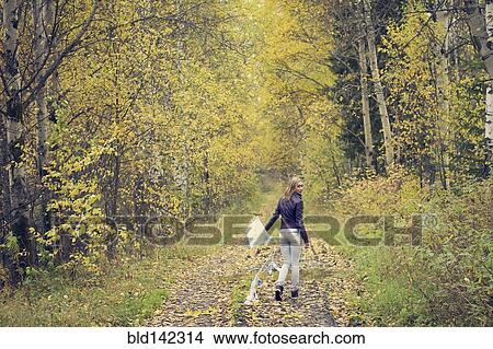 Woman carrying kite on dirt path View Large Photo Image Picture - Woman carrying kite on dirt path. Fotosearch