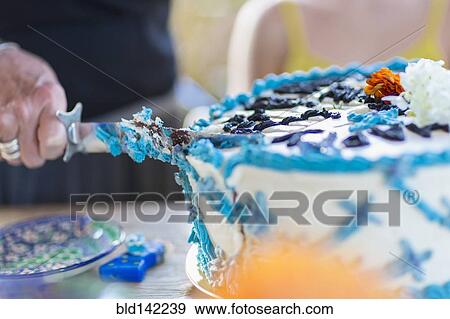 Woman cutting birthday cake at party View Large Photo Image Stock Photo - Woman cutting birthday cake at party. Fotosearch