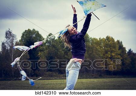 Woman flying kite in field View Large Photo Image Stock Image - Woman flying kite in field. Fotosearch