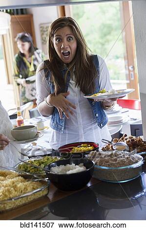Woman gasping and holding plate of food at party View Large Photo Image Stock Photo - Woman gasping and holding plate of food at party. Fotosearch