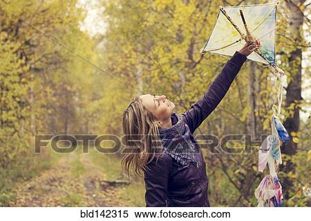 Stock Photography - Woman holding kite in forest. Fotosearch