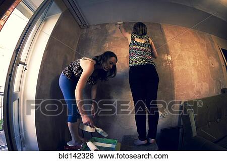 Stock Photo - Women painting wall. Fotosearch