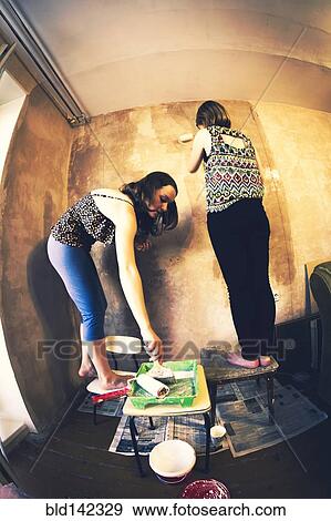 Stock Photo - Women painting wall. Fotosearch