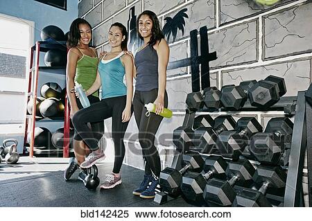 Stock Photography - Women smiling together in gym. Fotosearch