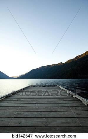 Stock Photo - Wooden deck at lake under blue sky. Fotosearch