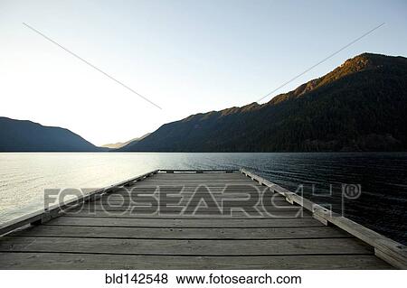 Stock Photo - Wooden deck at lake under blue sky. Fotosearch