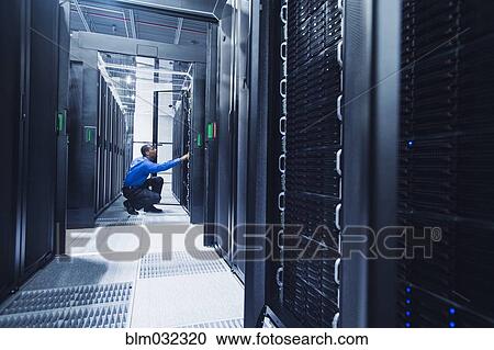 Black businessman working in server room View Large Photo Image Stock Image - Black businessman working in server room. Fotosearch