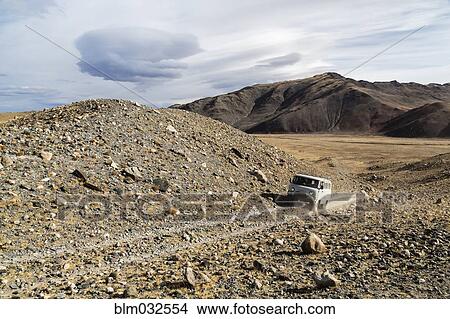 Bus driving through rocky desert landscape View Large Photo Image Picture - Bus driving through rocky desert landscape. Fotosearch