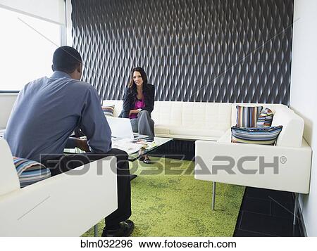 Stock Photograph - Business people talking in office lobby. Fotosearch