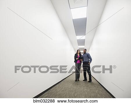 Business people talking in office corridor View Large Photo Image Stock Photo - Business people talking in office corridor. Fotosearch