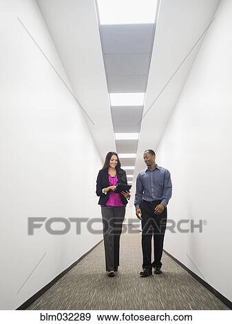 Stock Photo - Business people talking in office corridor. Fotosearch