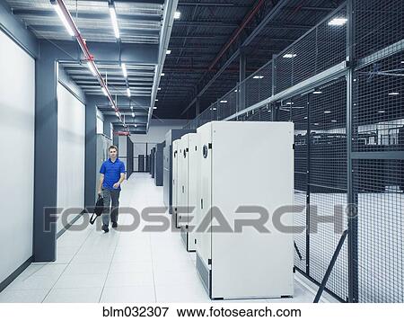 Stock Photo - Caucasian businessman walking in server room. Fotosearch