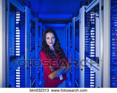 Stock Image - Caucasian businesswoman smiling in server room. Fotosearch