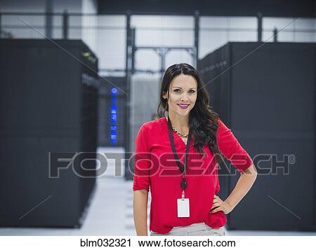 Stock Image - Caucasian businesswoman smiling in server room. Fotosearch
