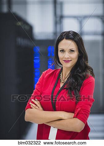Stock Image - Caucasian businesswoman smiling in server room. Fotosearch