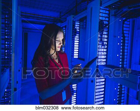 Stock Photo - Caucasian businesswoman using digital tablet in server room. Fotosearch
