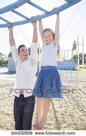Caucasian father and daughter playing at playground View Large Photo Image Stock Photo - Caucasian father and daughter playing at playground. Fotosearch
