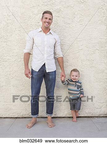 Caucasian father and son holding hands outdoors View Large Photo Image Stock Photo - Caucasian father and son holding hands outdoors. Fotosearch