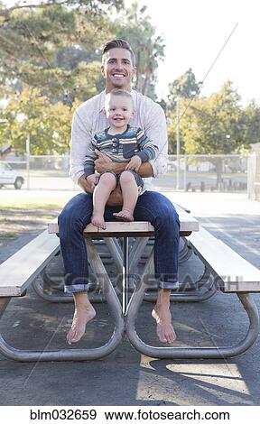 Caucasian father and son sitting on picnic table View Large Photo Image Stock Photo - Caucasian father and son sitting on picnic table. Fotosearch