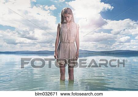 Stock Image - Caucasian girl standing in lake. Fotosearch