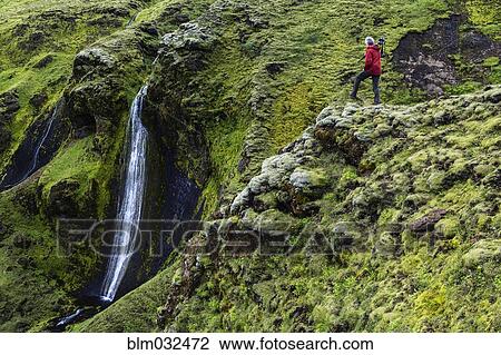Caucasian hiker admiring waterfall and rock formations on mountainside View Large Photo Image Stock Image - Caucasian hiker admiring waterfall and rock formations on mountainside. Fotosearch