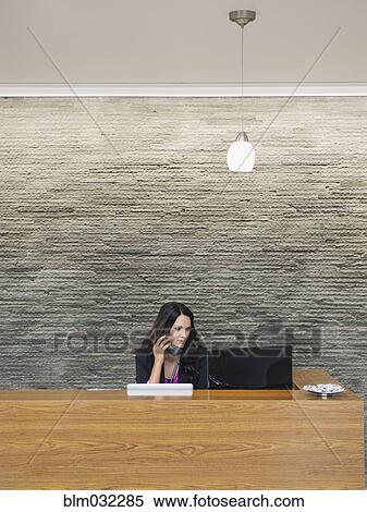Caucasian receptionist working at office front desk View Large Photo Image Stock Photography - Caucasian receptionist working at office front desk. Fotosearch
