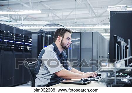 Caucasian technician using computer in server room View Large Photo Image Stock Photo - Caucasian technician using computer in server room. Fotosearch