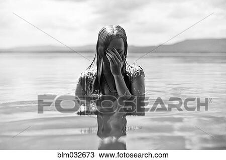 Caucasian teenage girl covering her face in lake View Large Photo Image Stock Image - Caucasian teenage girl covering her face in lake. Fotosearch