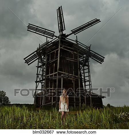 Caucasian teenage girl standing under wooden windmill View Large Photo Image Stock Photo - Caucasian teenage girl standing under wooden windmill. Fotosearch