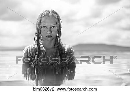 Stock Image - Caucasian teenage girl swimming in lake. Fotosearch