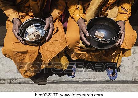 Stock Photo - Close up of monks collecting alms, Leh, Ladakh, India. Fotosearch