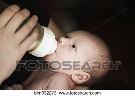 Stock Image - Close up of mother feeding newborn baby. Fotosearch