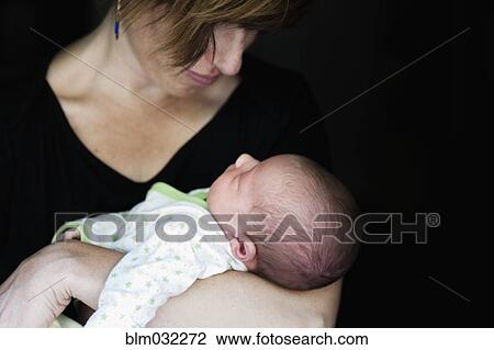 Stock Image - Close up of mother holding newborn baby. Fotosearch