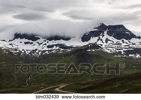 Clouds over snowy mountains in remote landscape View Large Photo Image Stock Photo - Clouds over snowy mountains in remote landscape. Fotosearch