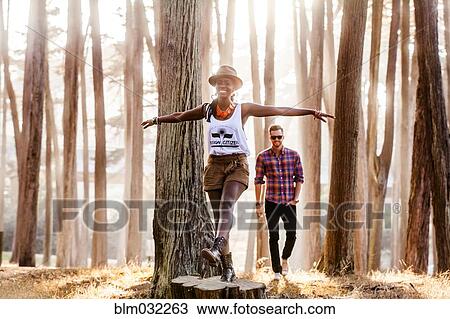 Stock Image - Couple exploring sunny forest. Fotosearch
