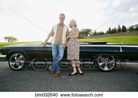 Couple smiling near classic convertible View Large Photo Image Stock Image - Couple smiling near classic convertible. Fotosearch