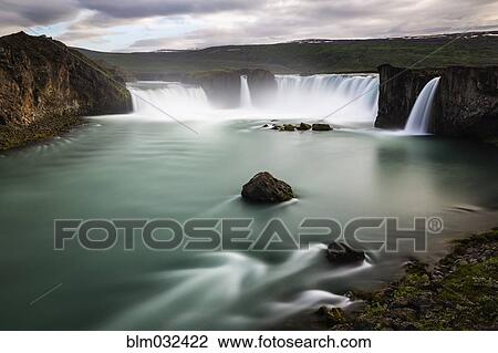 Stock Image - Godafoss waterfall over river in remote landscape, Akureyri, Iceland. Fotosearch